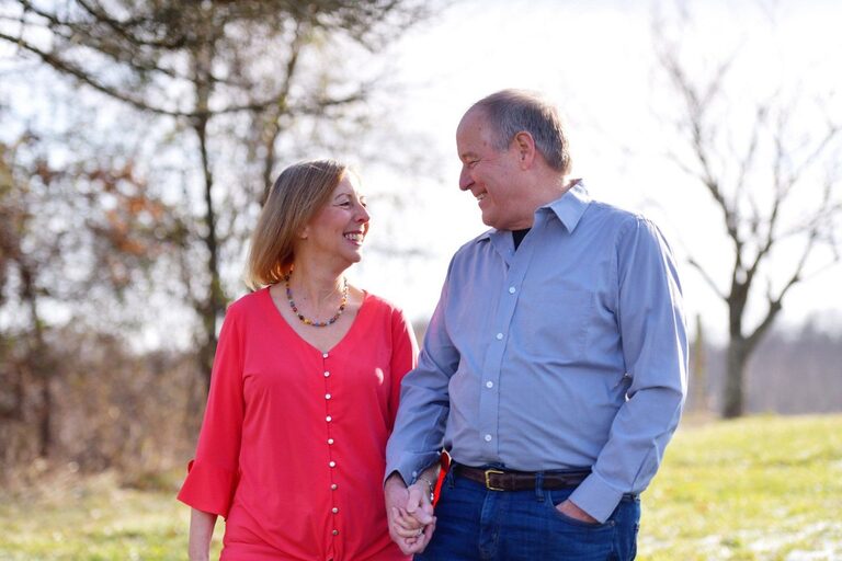 Gex Williams and his wife Judy holding hands outdoors