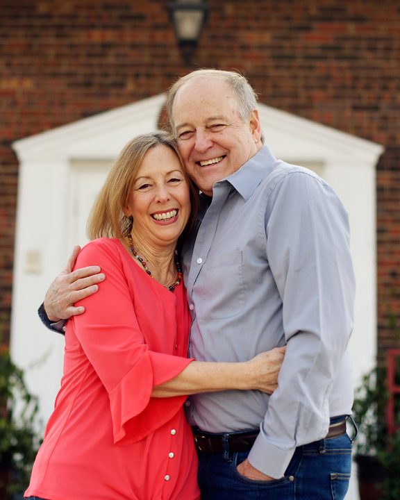 Gex Williams and his wife Judy in front of a brick house
